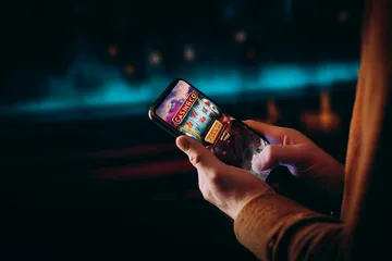 A close-up shot of golden coins falling around a spinning roulette wheel, representing immersive casino action at JILIX.